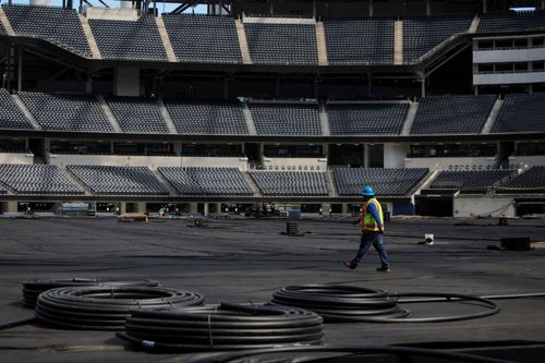 Một công nhân làm việc bên trong sân SoFi Stadium khi Los Angeles chuẩn bị cho World Cup 2026. Ảnh: Daniel Cole/Reuters.