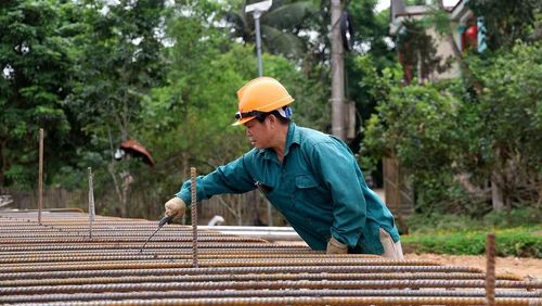 Công nhân thi công tuyến đường xuyên lễ, bảo đảm tiến độ dự án.