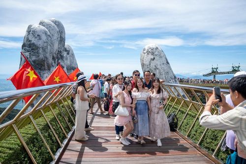 Các gia đình lưu lại khoảnh khắc đẹp trong tại cầu Vàng (Bà Nà Hills). Ảnh: Bình An