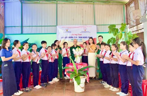Tặng hoa tri ân Đại tá Nguyễn Hữu Khuê tại chương trình “Mâm cơm nghĩa tình - Trọn lòng tri ân”. Ảnh: Minh Chí