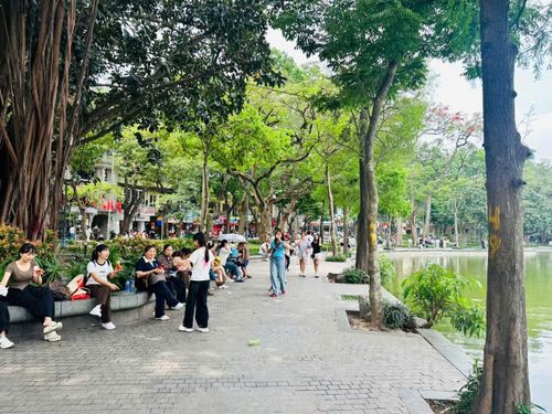 Du khách tận hưởng không khí mát rượi, trong lành bên hồ Gươm.