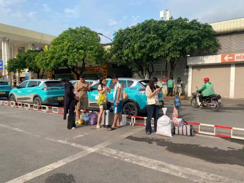 Tại bến, hành khách mang theo nhiều hành lý như vali, túi xách, thùng quà quê,... xếp thành từng cụm chờ xe.