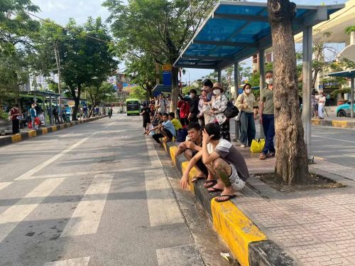 Người dân xuống xe khách tập trung tại điểm dừng chờ xe buýt để di chuyển vào thành phố.