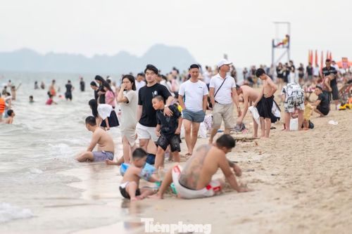  Trên bãi biển chật kín người tắm, đi dạo. 