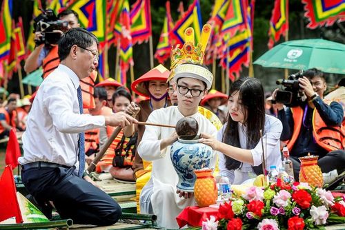 Phó Chủ tịch Thường trực UBND tỉnh Ninh Bình Trần Song Tùng thực hiện nghi lễ lấy nước vào chum, sau đó đoàn rước đưa về đền làm lễ