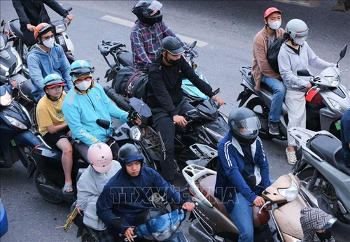 Người dân với hành lý, đồ đạc được chằng buộc cẩn thận hướng từ Quốc lộ 1A đi vào TP Hà Nội.