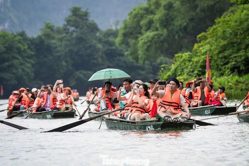 Hàng nghìn người dân và du khách thập phương ngồi trên thuyền xuôi theo đoàn rước, hòa mình vào không khí lễ hội linh thiêng và tranh thủ ghi lại khoảnh khắc đáng nhớ.