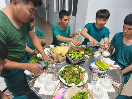 Lực lượng dân quân thường trực xã Phù Mỹ Đông quây quần trong bữa cơm ngày lễ, không khí vui tươi, ấm cúng, thắm tình đồng đội. Ảnh: H.P