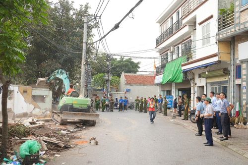 Lực lượng chức năng tổ chức cưỡng chế, tháo dỡ các ki-ốt vi phạm tại khu vực ao Đình thôn Dương Đá. Ảnh: PV