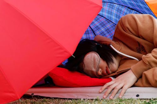  Một thí sinh tham gia cuộc thi ngủ ngon tại công viên bên sông Hàn ở Seoul, Hàn Quốc, ngày 2/5. 