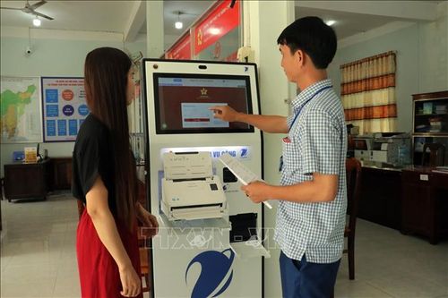 Cán bộ Trung tâm hành chính công xã Cát Tiên 2 hướng dẫn người dân nộp hồ sơ trực tuyến. Ảnh: Chu Quốc Hùng/TTXVN