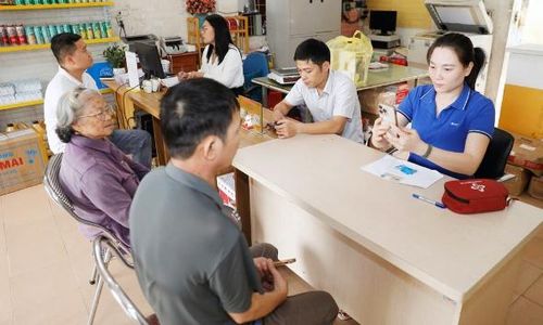 Nhân viên VNPT Bắc Ninh hỗ trợ người dân xác thực thông tin thuê bao di động tại điểm Bưu điện - Văn hóa xã Song Mai (phường Đa Mai).