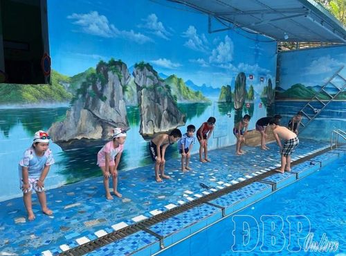 Trẻ được tập các động tác khởi động trước khi xuống nước tại bể bơi Tân Thanh.