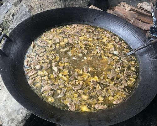 Người dân nấu thắng cố ngựa bằng bếp củi tại chợ phiên Si Ma Cai, phục vụ thực khách trong phiên chợ cuối tuần