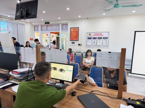 Cán bộ Công an phường Ô Chợ Dừa hỗ trợ người dân thực hiện thủ tục cấp Căn cước, định danh điện tử. Ảnh: P.V