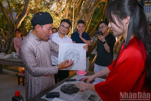 Khách tham quan tìm hiểu về nghệ thuật thư pháp.