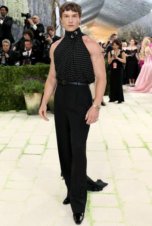 Connor Storrie khoe cánh tay săn chắc trong chiếc áo không tay cổ cao và quần cạp cao của Saint Laurent. Chiếc áo của anh thậm chí còn có chi tiết xếp nếp xòe rộng thành hình đuôi tôm. Ảnh: Getty