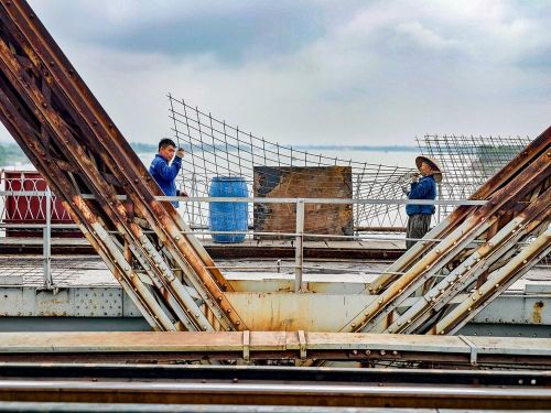 Công nhân duy trì thi công 3 ca liên tục trên mặt cầu Long Biên nhằm bảo đảm tiến độ thông cầu vào ngày 27/5/2026. Ảnh: Trung Nguyên - TTXVN