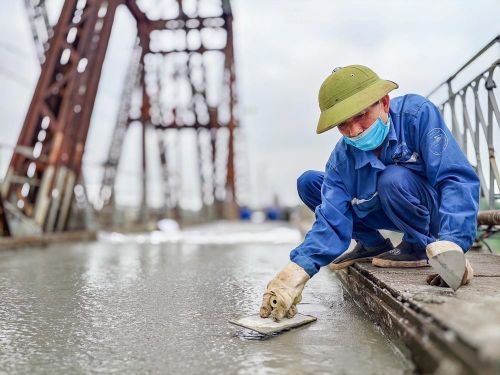 Công nhân duy trì thi công 3 ca liên tục trên mặt cầu Long Biên nhằm bảo đảm tiến độ thông cầu vào ngày 27/5/2026. Ảnh: Trung Nguyên - TTXVN