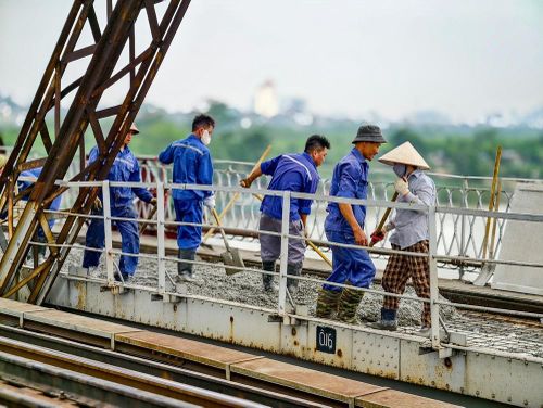 Lực lượng thi công tranh thủ làm việc từ sáng sớm, hạn chế thi công giữa trưa nắng nóng đầu mùa hè tại Hà Nội. Ảnh: Trung Nguyên - TTXVN