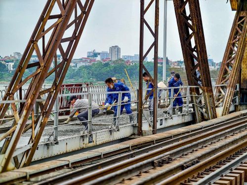 Các mũi thi công được chia nhỏ dọc mặt cầu Long Biên do điều kiện mặt bằng chật hẹp, phương tiện cơ giới lớn không thể tiếp cận. Ảnh: Trung Nguyên - TTXVN