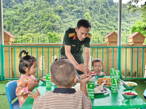 Các chú bộ đội Ban CHQS xã Kim Ngân ân cần bên các cháu.