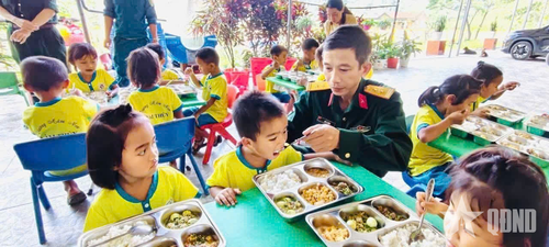 Trung tá Đỗ Lý Bằng, Chỉ huy trưởng Ban CHQS xã Kim Ngân ân cần bên các cháu nhỏ.