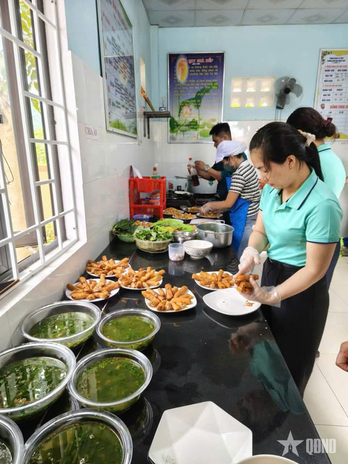 Ban CHQS xã Kim Ngân và các cô giáo Điểm trường Mầm non bản Bạch Đàn chế biến các món ăn.