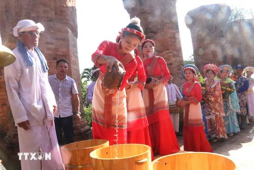 Thiếu nữ Chăm và thiếu nữ Việt trong trang phục truyền thống tham gia nghi lễ dâng nước lên Thánh Mẫu. (Ảnh: Đặng Tuấn/TTXVN)