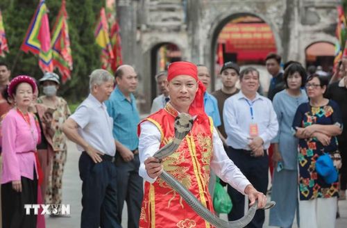 Nghệ nhân làng Lệ Mật biểu diễn múa rắn độc đáo, tái hiện huyền thoại chinh phục thủy quái. (Ảnh: Phan Phương/TTXVN)