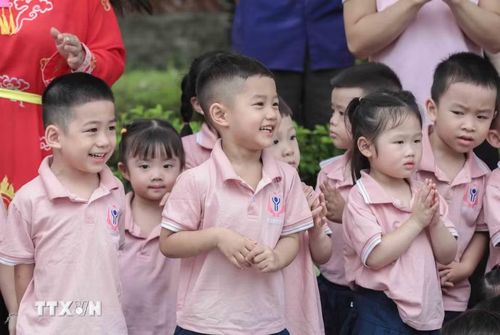 Các em nhỏ hào hứng xem tái hiện cảnh thanh niên họ Hoàng chiến đấu với Giảo Long cứu công chúa. Đây là nghi lễ đặc sắc trong Lễ hội làng Lệ Mật, một Di sản Văn hóa Phi vật thể Quốc gia. (Ảnh: Phan Phương/TTXVN)