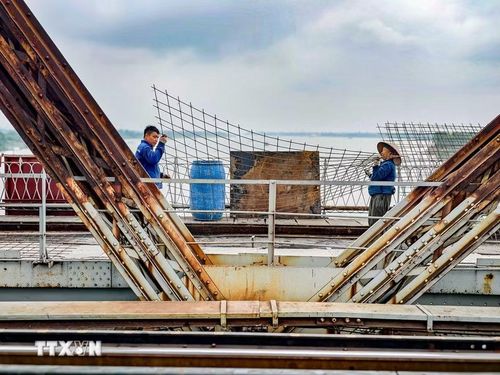 Công nhân duy trì thi công 3 ca liên tục trên mặt cầu Long Biên nhằm bảo đảm tiến độ thông cầu vào ngày 27/5/2026. (Ảnh: Trung Nguyên/TTXVN)
