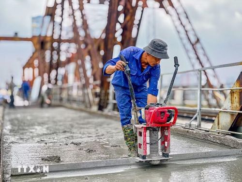 Công nhân duy trì thi công 3 ca liên tục trên mặt cầu Long Biên nhằm bảo đảm tiến độ thông cầu vào ngày 27/5/2026. (Ảnh: Trung Nguyên/TTXVN)