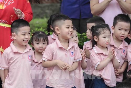 Các em nhỏ hào hứng xem tái hiện cảnh thanh niên họ Hoàng chiến đấu với Giảo Long cứu công chúa. Đây là nghi lễ đặc sắc trong Lễ hội làng Lệ Mật, một Di sản văn hóa phi vật thể quốc gia. Ảnh: Phan Phương – TTXVN