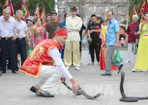 Nghệ nhân làng Lệ Mật biểu diễn màn múa rắn độc đáo, tái hiện huyền thoại chinh phục thủy quái. Ảnh: Phan Phương – TTXVN