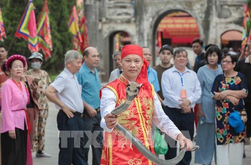 Nghệ nhân làng Lệ Mật biểu diễn múa rắn độc đáo, tái hiện huyền thoại chinh phục thủy quái. Ảnh: Phan Phương – TTXVN