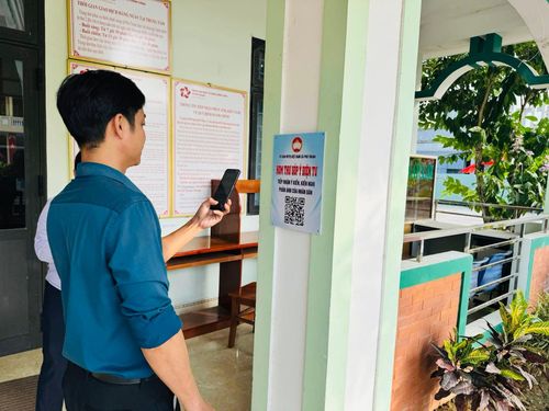 Người dân quét mã QR để gửi ý kiến, góp ý thông qua mô hình “Hòm thư góp ý điện tử” tại Trung tâm Hành chính công xã Phú Thuận. Ảnh: K.H
