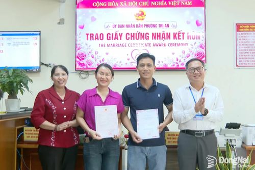 Lãnh đạo Ban Tuyên giáo và Dân vận Thành ủy cùng lãnh đạo phường Trị An trao giấy Chứng nhận kết hôn cho cặp đôi tại UBND phường. Ảnh: Văn Đoàn