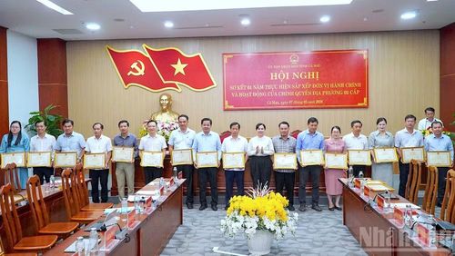 Phó Chủ tịch Hội đồng nhân dân tỉnh Cà Mau Lê Thị Nhung (đứng giữa) tặng Bằng khen cho các cá nhân có thành tích xuất sắc trong vận hành chính quyền địa phương 2 cấp.