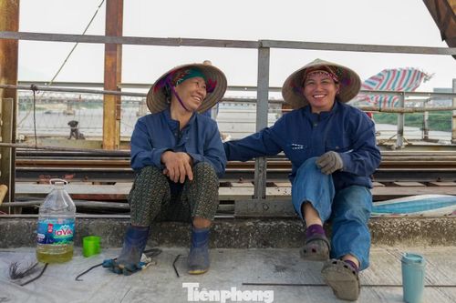 Phút nghỉ ngơi của các công nhân tham gia sửa chữa cầu Long Biên. Cô Đoàn Thơm (bên phải) cho biết, được góp sức cải tạo cây cầu lâu đời của Thủ đô khiến cô rất tự hào. “Dịp lễ chúng tôi vẫn làm việc để công trình sớm hoàn thành, người dân đi lại thuận tiện hơn”, cô Thơm chia sẻ.