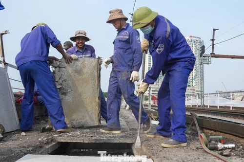 Các công nhân đang triển khai thay thế các tấm bê tông mặt cầu nhằm phục vụ quá trình cải tạo, sửa chữa công trình.