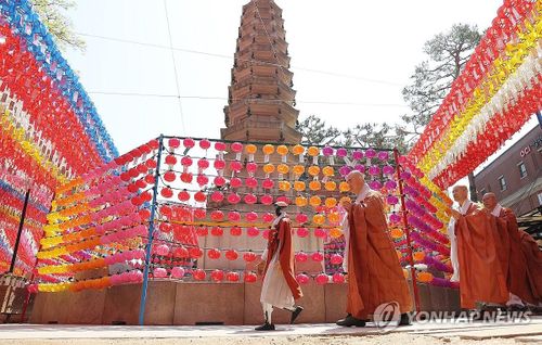 Gabi và các nhà sư đi vòng quanh chùa. Ảnh: Yonhap