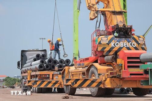 Các khung kết cấu tại khu vực khán đài cũng từng bước lộ diện. Trên công trường, phương tiện, máy móc chuyên dụng được huy động. Công nhân làm việc liên tục theo ca, duy trì nhịp độ thi công nhằm đáp ứng đúng tiến độ. (Ảnh: Minh Quyết/TTXVN)