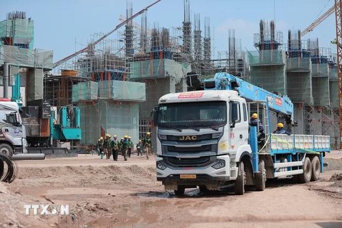 Các khung kết cấu tại khu vực khán đài cũng từng bước lộ diện. Trên công trường, phương tiện, máy móc chuyên dụng được huy động. Công nhân làm việc liên tục theo ca, duy trì nhịp độ thi công nhằm đáp ứng đúng tiến độ. (Ảnh: Minh Quyết/TTXVN)