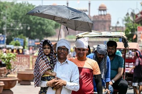 Người dân di chuyển dưới trời nắng nóng tại New Delhi, Ấn Độ. Ảnh: AFP/TTXVN