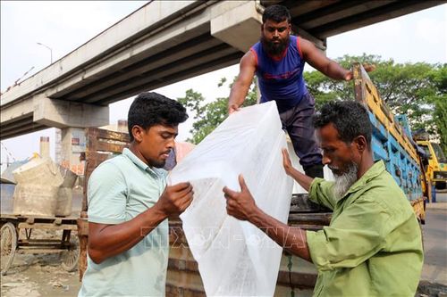 Công nhân vận chuyển đá lạnh trong ngày nắng nóng ở Dhaka, Bangladesh. Ảnh: THX/TTXVN