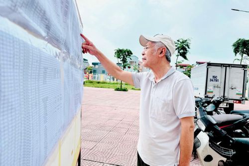 Người dân xã Nam Phù theo dõi thông tin công bố thu hồi đất phục vụ dự án đường Vành đai 3,5. Ảnh: Phương Xuyến