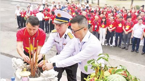 Đồng chí Lê Quốc Minh, Tổng Biên tập Báo Nhân Dân và lãnh đạo Đoàn công tác số 25 cùng đội ngũ những người làm báo dâng hương tại Tượng đài tưởng niệm các chiến sĩ Đoàn tàu không số anh hùng. (Ảnh: ĐỨC NGHĨA)