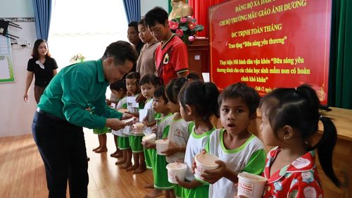 Đồng chí Trịnh Toàn Thắng, đảng viên Chi bộ các cơ quan Đảng xã Đắk Ơ trao bữa ăn sáng cho học sinh nghèo.