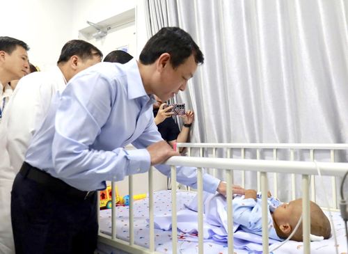 Thứ trưởng Bộ Y tế ân cần thăm hỏi em bé.